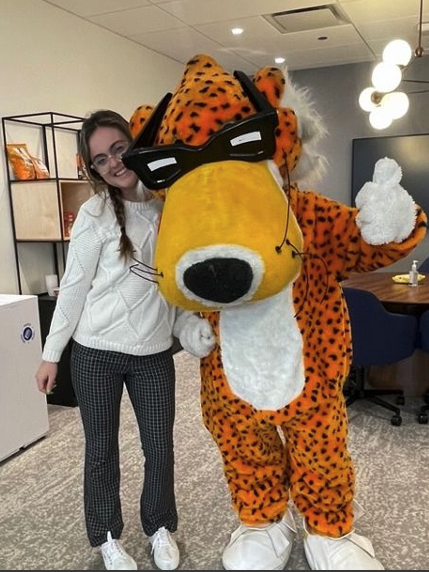 A packaign science co-op poses with the Cheetos Tiger at Frito-Lay